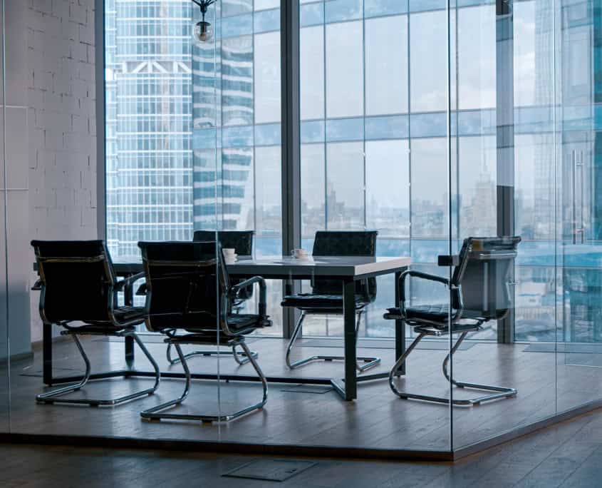 Side view of modern clean office space next to floor to ceiling high rise windows