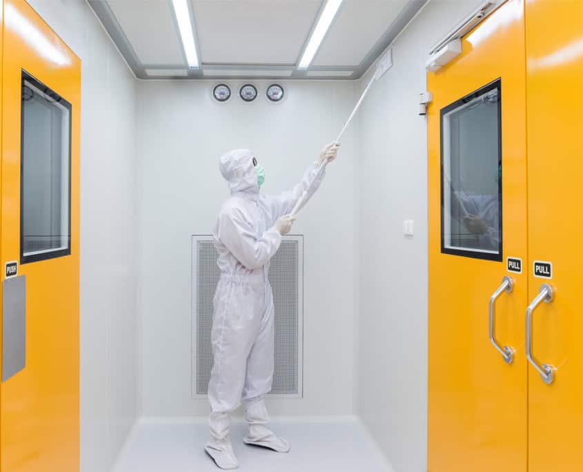 A worker in sterile coverall gown using Cleaning tool for cleaning laboratory. Cleanroom facility.