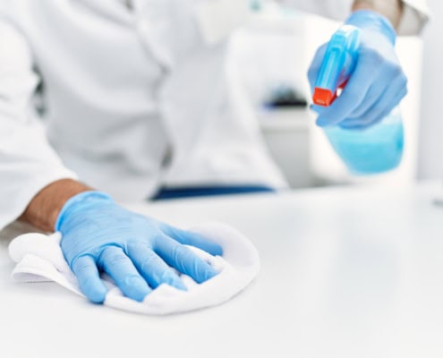 Handsome hispanic man working as scientific cleaning the table at laboratory